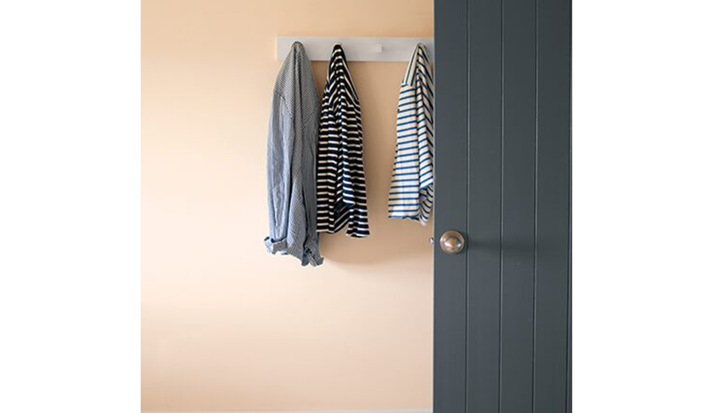 A peach-painted wall with white trim and gray doors.