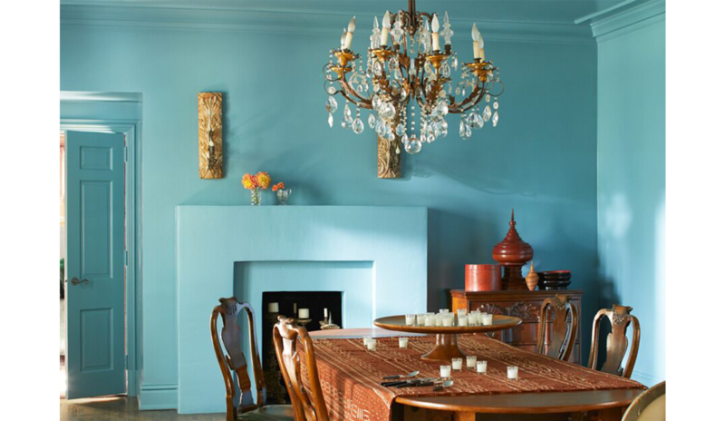 Blue-painted opulent dining room with exotic classic style, chandelier, large wooden table and chair