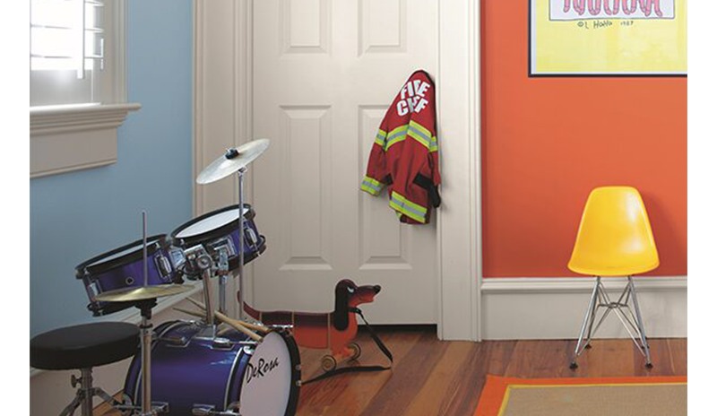 Área de juegos: paredes naranja/azul, pintura dinosaurios, silla amarilla y chaqueta bombero Play area: orange & blue walls, dinosaur painting, yellow chair, blue drum set, child's fireman jack