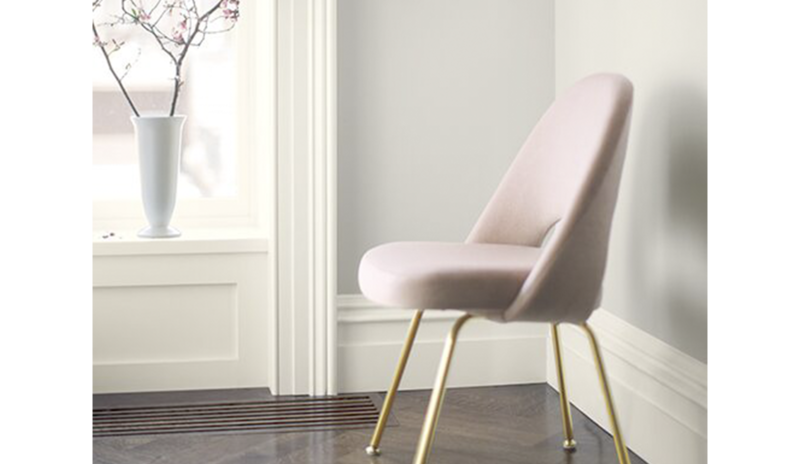A pink chair frames a wall painted in Balboa Mist OC-27.