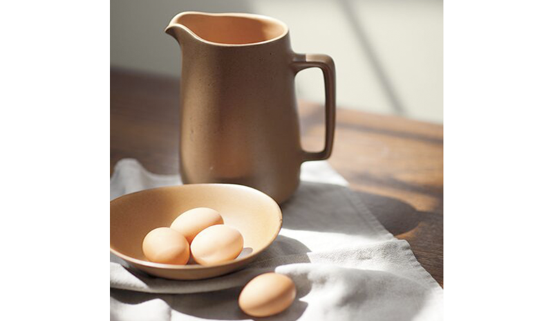 A water jug and bowl of eggs set against a wall painted in Wish AF-680.