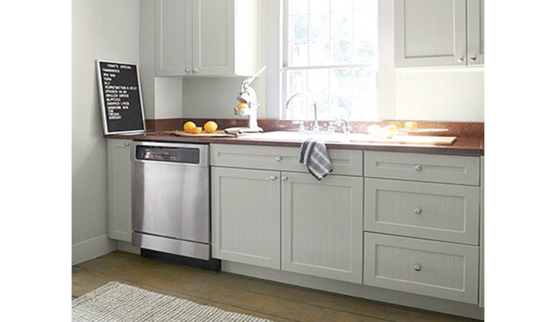 An airy kitchen with walls, cabinets and trim painted in Titanium OC-49, a light greige.