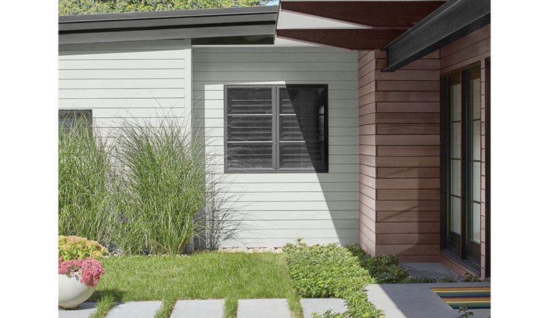 A light, gray-painted modern house with black trim and brown stain A light, gray-painted modern house with black trim and brown stain