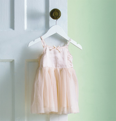 A pale green-painted wall frames a toddler's tutu. A pale green-painted wall frames a toddler's tutu.