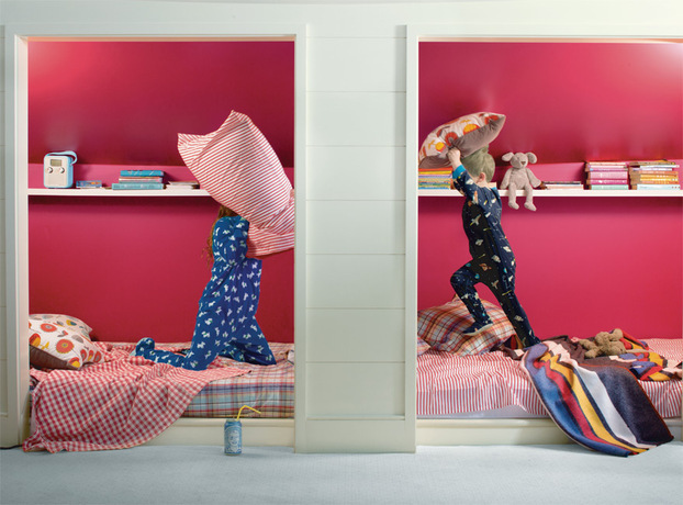 Bright red paint frames two kids having a pillow fight in a dual-bedded alcove. Bright red paint frames two kids having a pillow fight in a dual-bedded alcove.