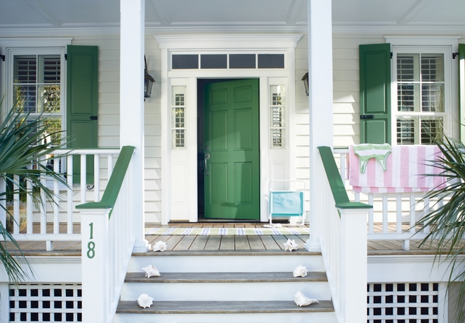 Residential exterior featuring front porch, entry door with transom and sidellights
