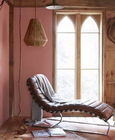 Sitting area with red walls and leather lounge chair.