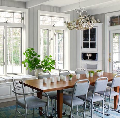 An airy dining room in grays and whites invites guests to the table. An airy dining room in grays and whites invites guests to the table.