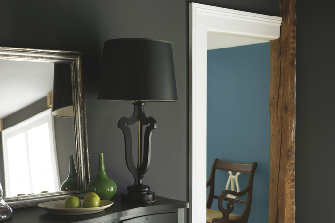 A deep charcoal gray wall is complemented by a turquoise blue accent wall in the neighboring room. A deep charcoal gray wall is complemented by a turquoise blue accent wall in the neighboring room.