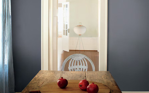 Rustic plank table with gray-blue wall and pomegranates