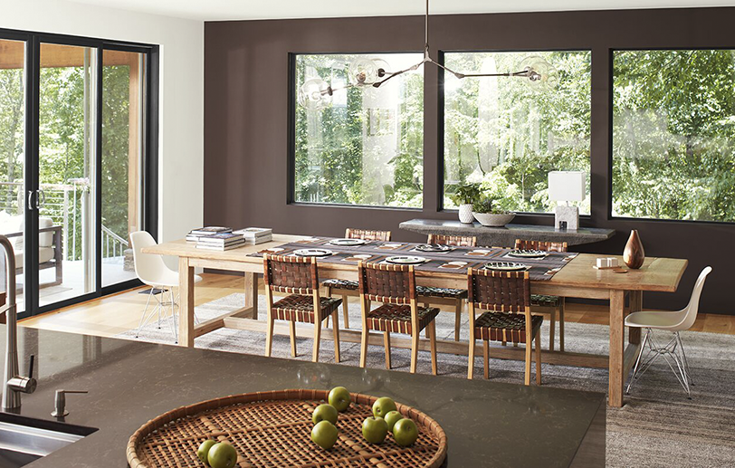 Modern dining room with brown accent wall, white ceiling & glass doors, and brown granite island. Modern dining room with brown accent wall, white ceiling & glass doors, and brown granite island.