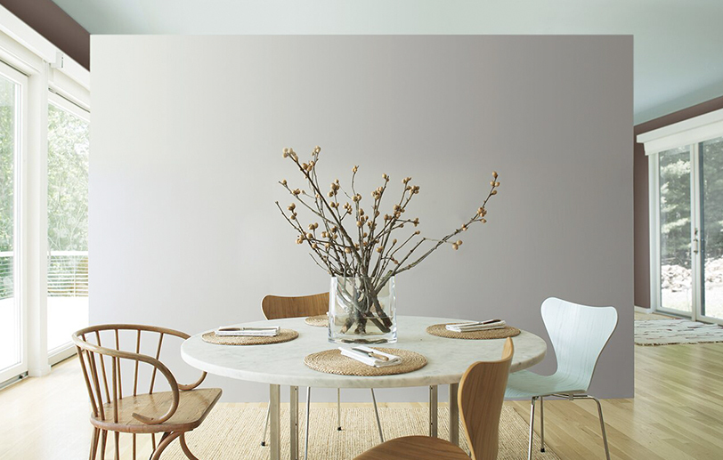 Airy kitchen with gray accent wall and mint ceiling; circular table with wooden chairs. Airy kitchen with gray accent wall and mint ceiling; circular table with wooden chairs.