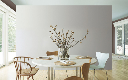 Airy kitchen with gray accent wall and mint ceiling;  circular table with wooden chairs.
